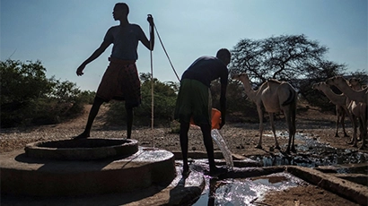 Men extract water from a well at the village of El Gel, near the town of K'elafo, Ethiopia